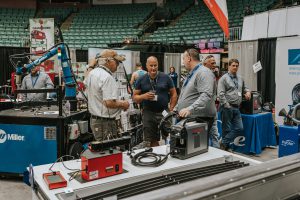 Three men having a discussion at a heavy equipment trade event